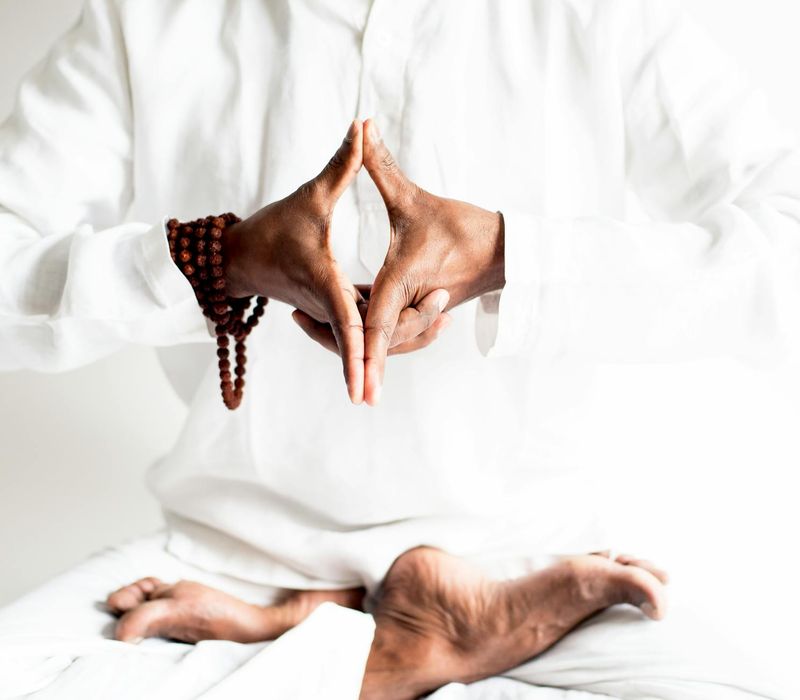 Close-up of a person's hands in a mudra gesture during breathing practice.