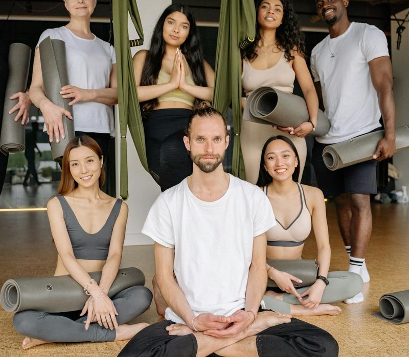 Diverse group of people smiling during a gentle yoga class.